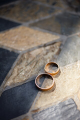 Pair of Golden Wedding Rings on Textured Stone Surface
