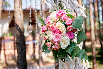 Beautiful Floral Arrangement with Pink and White Roses on a Rustic Outdoor Arch