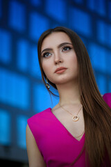 Portrait of beautiful young girl at city center among office buildings