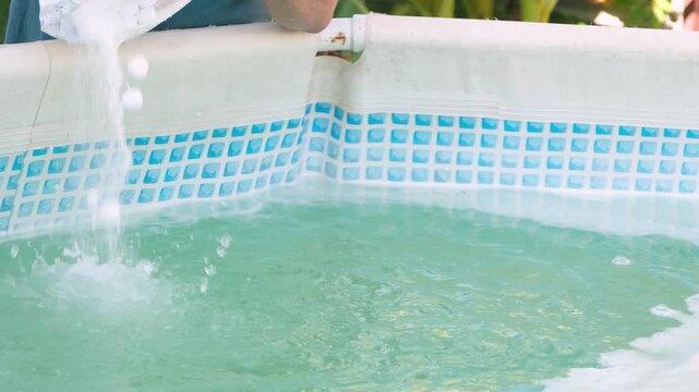 Man adding salt to the frame swimming pool for cleaning and filtration