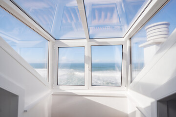 Modern Glass Room With Stunning Ocean and Blue Sky View