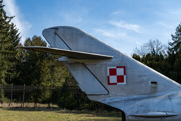 Historic Polish military aircraft tail section displayed in a nature setting