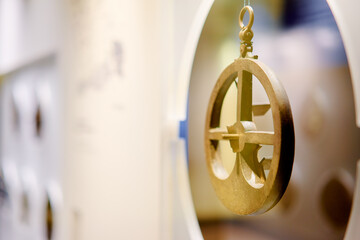 Close-up of an ancient astrolabe displayed in a museum setting.