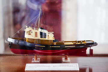 Detailed Wooden Model of a Tugboat Displayed in a Protective Glass Case