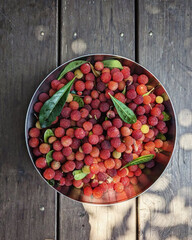 Metal bowl filled with fresh red berries.