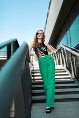 Portrait of beautiful young model in shiny clothe in city center