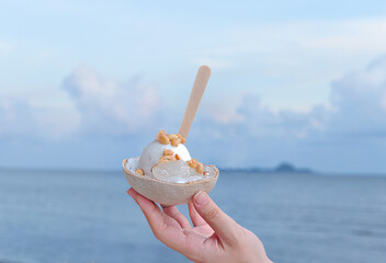cocount ice cream in hand against the backdrop of the sea happy  and relax with the concept of the...