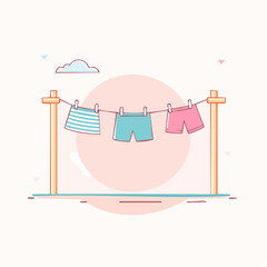 Colorful laundry a striped skirt and two pairs of shorts hanging on a clothesline with clothespins.