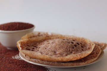Ragi appams with crisp edges and soft centers served on a ceramic plate, made from fermented finger...
