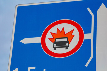 Blue circular traffic prohibition sign featuring red maple leaf symbol with white prohibition bar...