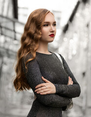 Portrait of beautiful young model in shiny clothe in city center