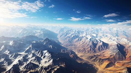 Vast mountain range, snow-capped peaks, dramatic valleys, vibrant colors, clear sky