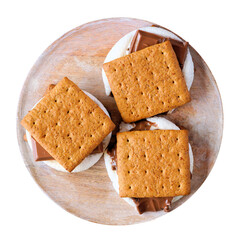Classic smores dessert on a wooden plate. Top view isolated on a white background.