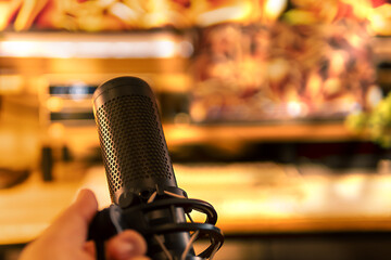 A person grips a microphone surrounded by a glowing workspace, highlighting focus and creativity.