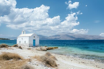 Picturesque white church standing on a sandy beach by the aegean sea with mountains in the background, a peaceful and serene greek landscape