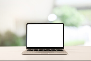close up blank white screen display of laptop computer on table in office building with garden...