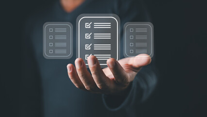 A person holds a digital interface displaying three floating icons representing a checklist document with checkboxes and lines, symbolizing digital tasks, workflow, and organization efficiency.