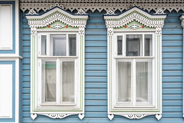 Fragment of the facade of a wooden russian house of the 19th century with carved decor based on...