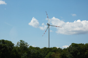 Wind Turbine Against Blue Sky and Trees