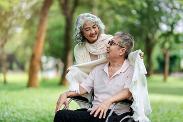 Elderly couple sharing heartwarming care and support in a beautiful tranquil outdoor park setting fostering loving companionship and joyful moments together