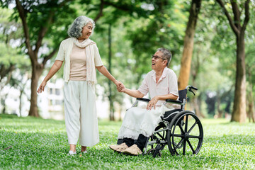 Senior couple enjoying peaceful walk holding hands sharing laughter in a beautiful green outdoor park