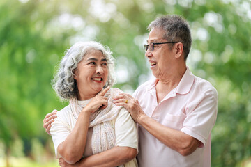 Elderly couple sharing joyful laughter and heartfelt conversation together in a peaceful serene outdoor park environment