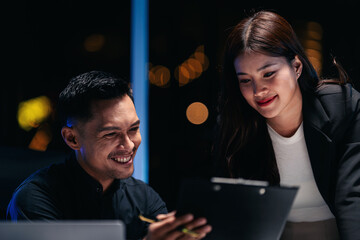 Professional adult colleagues collaborating effectively on project during late night office hours teamwork discussion solution