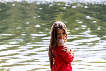 Elegant woman in red dress by the lake