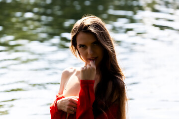 Elegant woman in red dress by the lake