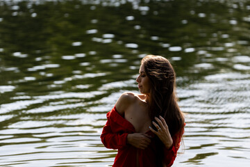 Elegant woman in red dress by the lake