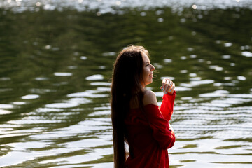 Elegant woman in red dress by the lake