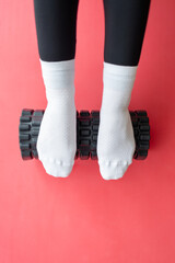 foot massage using a roller with spikes. close-up of a girl's feet doing yoga, roll with spikes for...