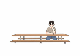 Young boy sitting alone at lunch table with thoughtful expression  