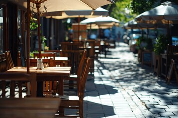 Outdoor cafe with wooden tables and chairs on a sunlit patio surrounded by greenery and calm ambiance