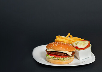 Delicious burgers with beef, tomato, cheese and lettuce. French fries and salat on the side
