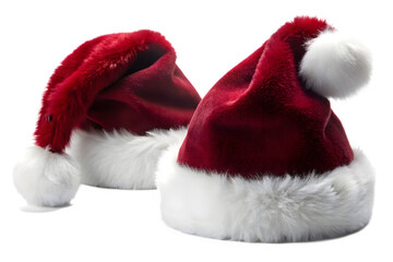 Two plush red santa hats with soft white fur trim and pompoms, artfully arranged on a transparent background