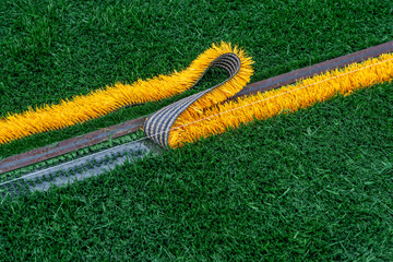 Synthetic turf field under construction with lines and graphics being installed.	