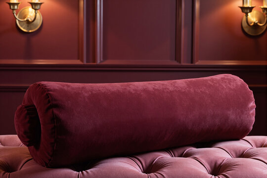 Luxurious burgundy velvet bolster pillow resting on a tufted leather bench, a comfortable and elegant decorative accessory for a sophisticated and classic interior