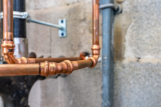 Press-fit fittings, copper pipe plumbing connections and fittings for new potable water pipes in a bathroom.
