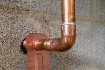 Soldered copper pipe plumbing connections and fittings for new potable water pipes in a bathroom.