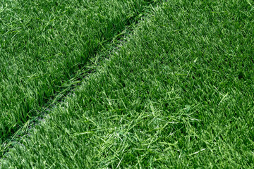 Synthetic turf field under construction with lines and graphics being installed.	