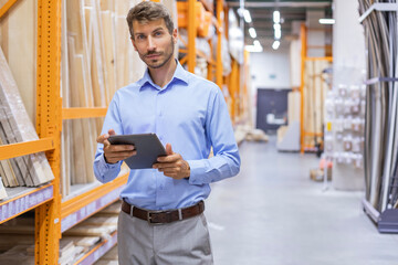 Portrait of happy man using digital tablet in hardware store