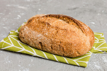 freshly baked bread with napkin on rustic table top view. Healthy white bread loaf isolated