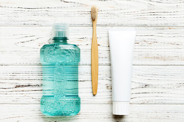 Mouthwash and other oral hygiene products on colored table top view with copy space. Flat lay....