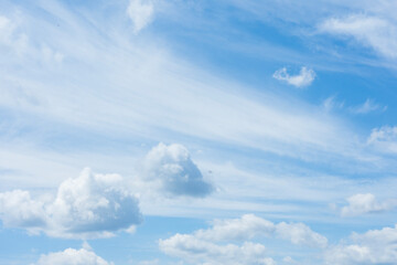 Bright and peaceful view of a blue sky filled with scattered, fluffy white clouds. Concept for...
