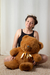 Young woman posing with her favorite childhood toy, a big red bear, nostalgia