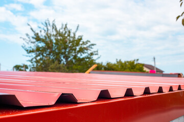Metal roof sheet with wavy edges against the sky. Roof construction