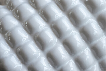 Shiny and reflective white ceramic object with 3D effect projections. Abstract backgrounds