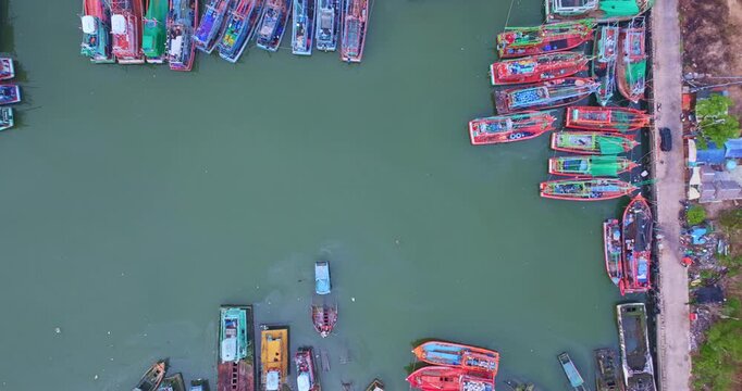 A fleet of fishing boats creates gentle ripples in the dock, The coastal landscape of Phuket, It&rsquo;s a scene of motion and stillness, where the economy and environment coexist in visual harmony.