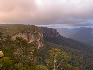 A view of the Blue Mountains National Park in New South Wales, Australia. The image shows a vast...